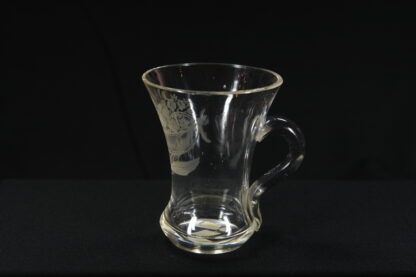 Becherglas, 2. Hälfte 19. Jh., farbloses Glas, mit Henkel, verziert in feinem Schliff mit Blumenstrauß und Inschrift: "Zum Andenken", unbeschädigt. H: 10 cm, www.beyreuther.de