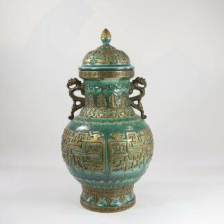 Deckelvase, China, 20. Jh., im archaischen Stil mit Mustern und Friesen,, grün glasiert und goldstaffiert, balsuterförmiger Korpus, seitlich Drachenhandhaben, aufgewölbter Deckel mit Zapfenknauf, Bodenmarke, unbeschädigt. H: 43 cm, Vase with cover, China, 20th century, in archaic style with ornaments, green gloss, undamaged, www.beyreuther.de