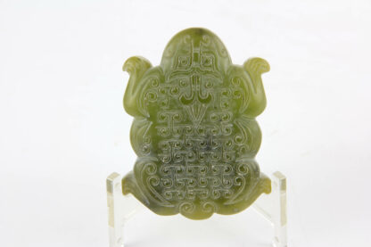 Talisman, China, grüne Jade, geschnitzt, in Form eines Fabelwesens im archaischen Stil im Maul Reste eines Bronzerings. 6,5 cm x 4,5 cm, www.beyreuther.de