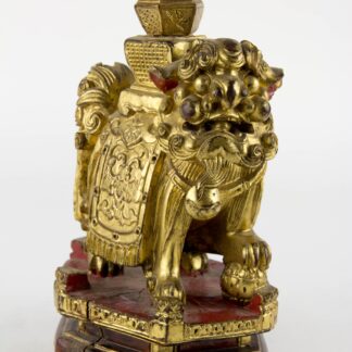 Figur, China, 19./20. Jh., Holz geschnitzt, Fo-Hund mit Vase auf Rücken, auf Sockel stehend, mit Rotlack überzogen und vergoldet. Schwundriss im Sockel, Gebrauchsspuren, schöne Arbeit. H: 20 cm.