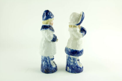 Paar Porzellanfiguren, um 1900, ungemarkt, Mädchen und Junge in Wintersachen, blau-weiß bemalt, im Fuß des Mädchens Brandrisse, sonst unbeschädigt. H: 22 cm.