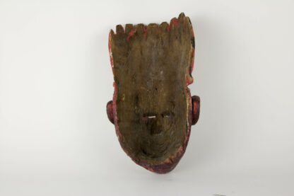 Holzmaske, 20. Jh., dunkelrot bemalt, beschädigt, Tragespuren. L: 36 cm.