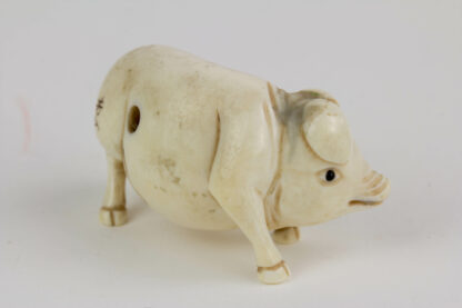 Netsuke, Japan, Meiji-Zeit, Bein, Schwein, Augen schwarz abgesetzt, signiert, Gebrauchsspuren, L: 5 cm.