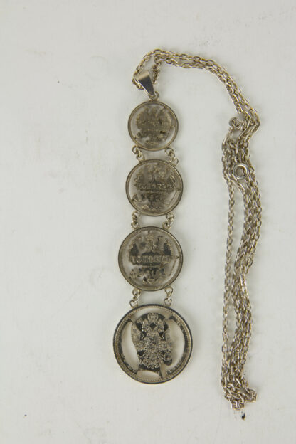 Kette, Russland, um 1915, gefertigt aus 4 Silbermünzen, 3 Kopekenmünen mit ausgeschnitten Zarenadler, als Abschluss 1 Rubel mit dem Portrait von Zar Nikolaus II, schöne Fertigung, leichte Tragespuren. L: 39 cm, www.beyreuther.de