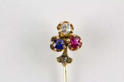Krawattennadel, um 1900, 585er Gold, ungemarkt, in Form eines Kleebalttes, mit Saphier, Diamant und Rubin besetzt, im Stil kleiner Rosendiamant. L: 5,5 cm. www.beyreuther.de