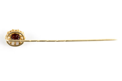 Krawattennadel, Ende 19. Jh., Gold, gemarkt Fuchs 4, mittig geschliffener Granat, flankiert von kleinen Opalen, schöne Juwelierarbeit. L: 7 cm.