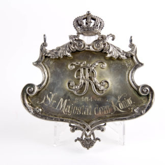 Großes Schild, um 1900, Silber, gestempelt Miller 800, zum Aufhängen, mittig KR für Ulanen Regiment König Karl, Nr. 19, (1. Württembergisches), mit Inschrift: "gestiftet von Sr. Majestät dem König", dieses Schild ist ein Geschenk des Königs von Württemberg Wilhelm II an sein Regiment, wohl für das Offizierskasino, Wilhelm der II. von Württemberg war ab 1891 Regimentsinhaber, Fehlstelle an Krone und Ornament, sonst schöne Juwelierarbeit, 281 g. 15 cm x 16 cm.