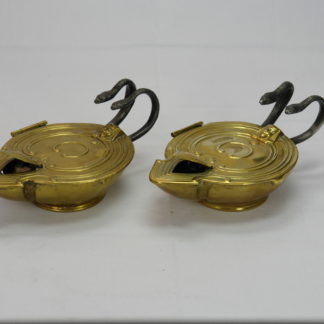 Paar Öllampen, um 1900, im Antiken Stil, Messing, Griffe als Schlangen aus Eisen, beim Zusammendrücken der Schlangen entzündet sich der Docht, Mechanik zu überholen, selten und originell. B: 7 cm, H: 10 cm, L. 17 cm. www.beyreuther.de