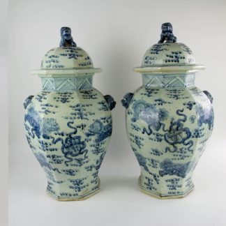 Paar Vasen, China, Mitte 20. Jh., umlaufend mit Fo-Hunden und Ornamenten in Blaumalerei verziert, Handhaben in Form von Löwenköpfen, Deckelbekrönung als plastische Fo-Hunde gearbeitet, sehr dekorativ, unbeschädigt, Gebrauchsspuren. H: 68 cm, D: 36 cm.