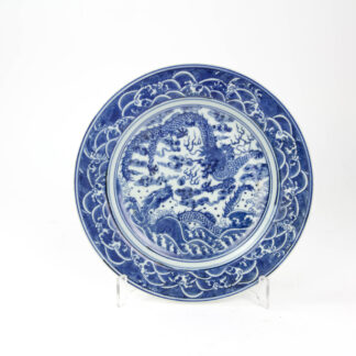 Teller, China, 19./20. Jh., ungemarkt, im Spiegel mit zwei Drachen in Blaumalerei verziert, Fahne mit Wellen bemalt, leichte Gebrauchsspuren, unbeschädigt, D: 23 cm.