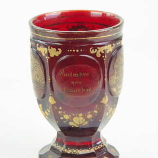 Bäder-Becher, um 1870, Rubinglas, geschliffen, mit Goldmalerei verziert, 5 Kartuschen in vier davon Ansichten der Andenken an Karlsbad, Gebrauchsspuren, Abrieb, H: 13 cm.