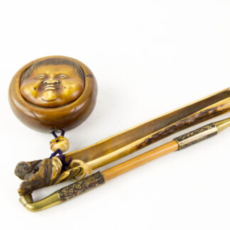Opiutmpfeife, Kiseruzutsu, Japan, Meiji-Zeit, mit Behälter und geschnitzter Dose für Opium, Behälter aus Hirschhorn, verzierte Metallpfeife, Verbindungsstück zwischen  Dose und Behälter plastisch geschnitzter Totenkopf, runde Dose aus Holz, mit geschnitzten Deckel als Gesicht, sehr hochwertige Arbeit, Provenienz: Dr. Anton Kohlmann (1889-1949). L: 20 cm.