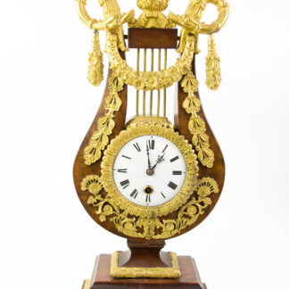 Prunk-Pendule, Anf. 19. Jh., in Form einer Lyra auf Sockel, Mahagoni furniert, reich mit feuervergoldeten Beschlägen verziert, Abschluss David mit Zackenkrone (biblischer König David), flankiert von 2 Schlangen, Email-Ziffernblatt, Fadenaufhängung mit Pendel, ohne Schlagwerk, Schlüssel fehlt, Uhrwerk nicht revidiert, Reparatur oder Reinigung durch Uhrmacher möglich, Gebrauchsspuren. H: 48 cm.