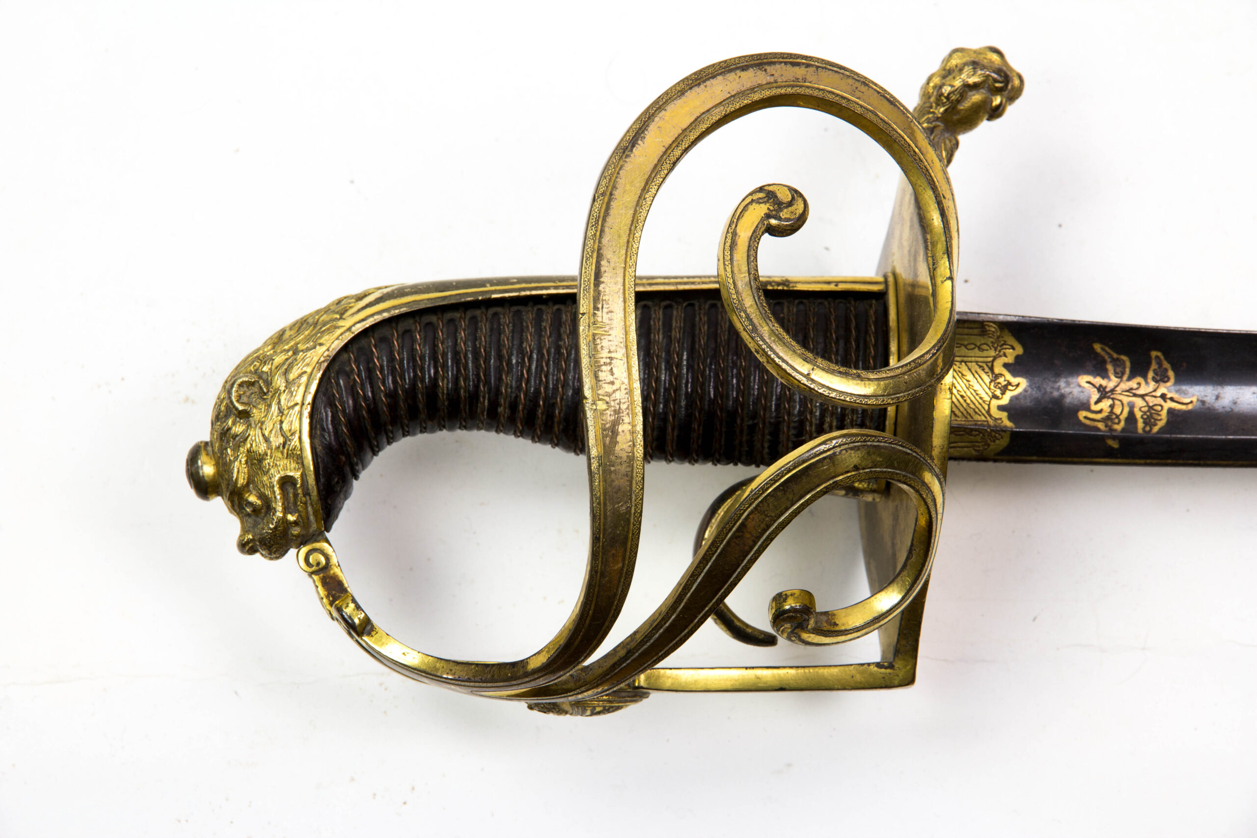 Offizierssäbel, Sachsen, nach 1806, Leibkürassier - Garde, Löwenkopfgefäß mit 3 Nebenbügeln, zwei davon eingerollt, Bronze, ovales Stichblatt in einer Löwentatze endend, Holzgriffstück mit Leber überzogen und Drahtwicklung, sächsisches Wappen auf dem Hauptbügel, Rückenklinge mit Hohlschliff, im ersten Drittel gebläut, vergoldet und mit Ornamenten und Kriegsgirlanden verziert, dazu Messingscheide mit zwei plastischen Löwenköpfen und Trageringen, Reste einer Vergoldung, absolut unberührtes Stück mit schöner Patina und guter Erhaltung, das Regiment wurde 1822 in Russland komplett aufgerieben, einzigartiges Stück. L: 101 cm.