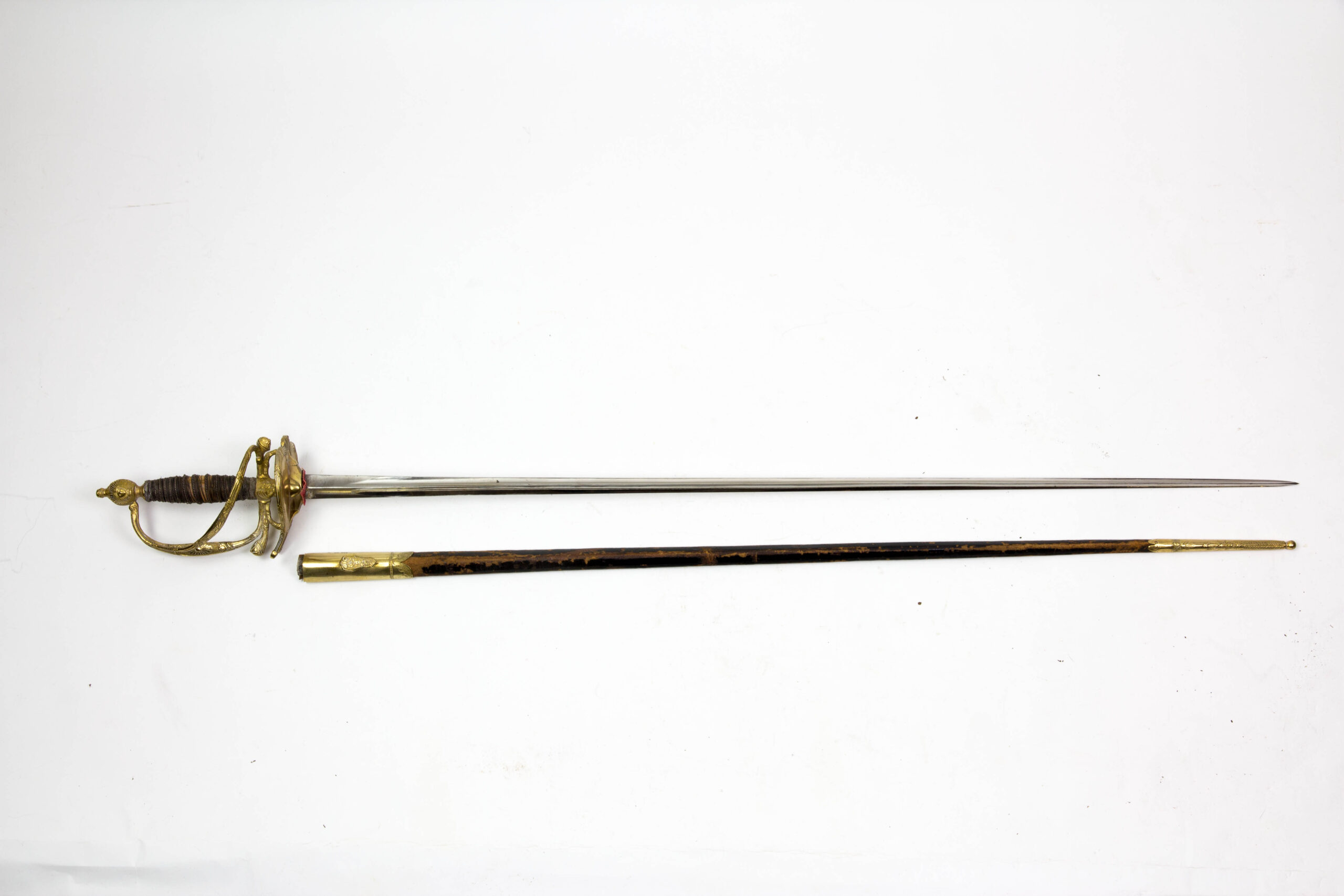 Degen, Frankreich, Modell 1772, 2. Restauration, Gendarmarie de la Garde, vergoldetes Bronzegefäß mit floralen Ornamenten und Girlanden verziert, Silberdrahtwicklung, runder Abschlussknauf mit Sonne und Querbügel, (so nicht bekannt), abklappbares Stichblatt, polierte Dreikantklinge, schwarze Lederscheide (Naht hat sich gelöst, Fehlstellen im Lack), sehr guter Originalzustand, extrem selten, wohl Unikat, vergl. Jean Lhoste Les Épées, Seite 197 und 345. L: 100 cm.